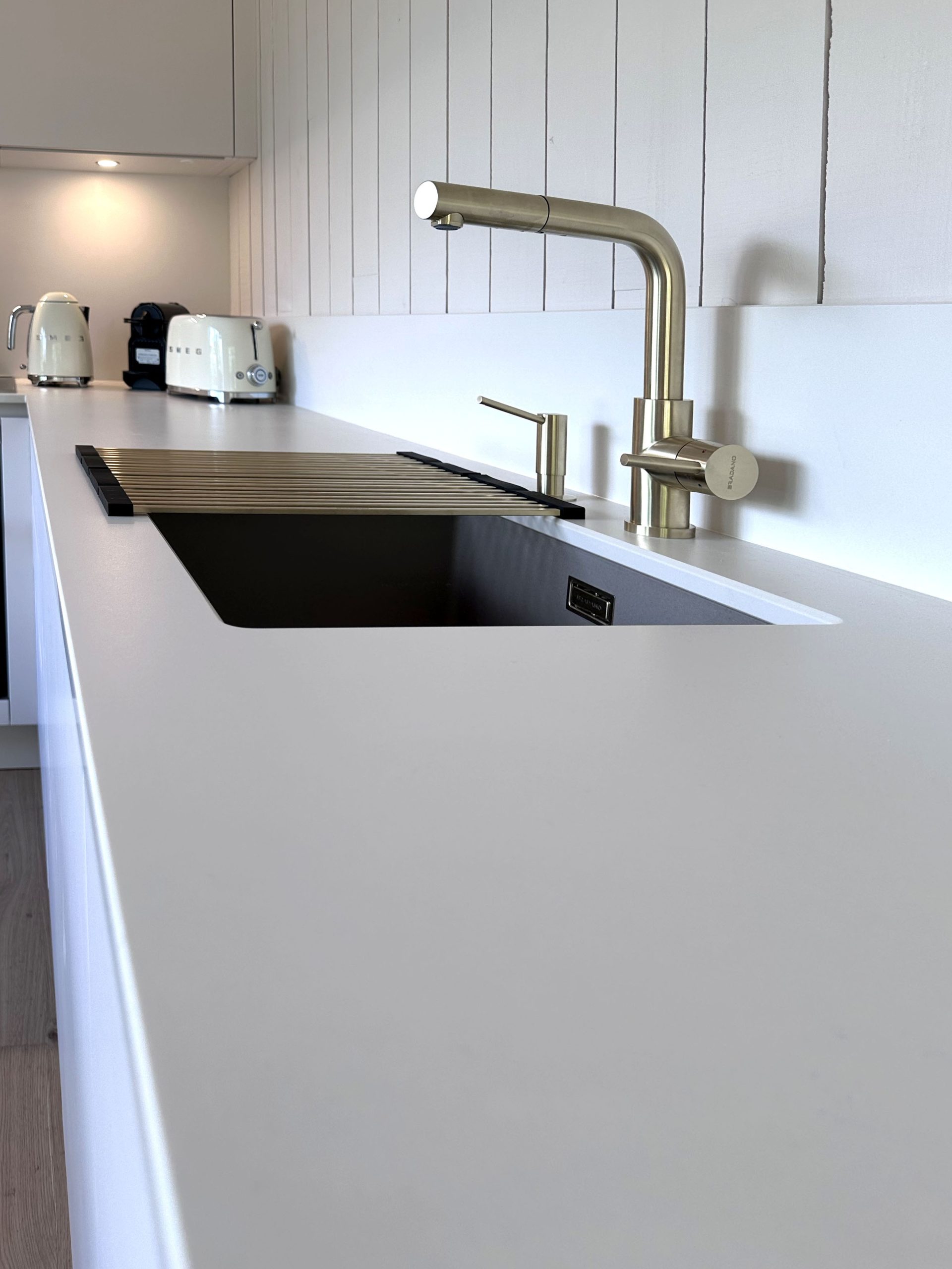 Lavello con rubinetto in ottone su piano Dekton Mooné, nella cucina Zecchinon firmata Quartier Cuisine per una casa vacanze al Cap Ferret