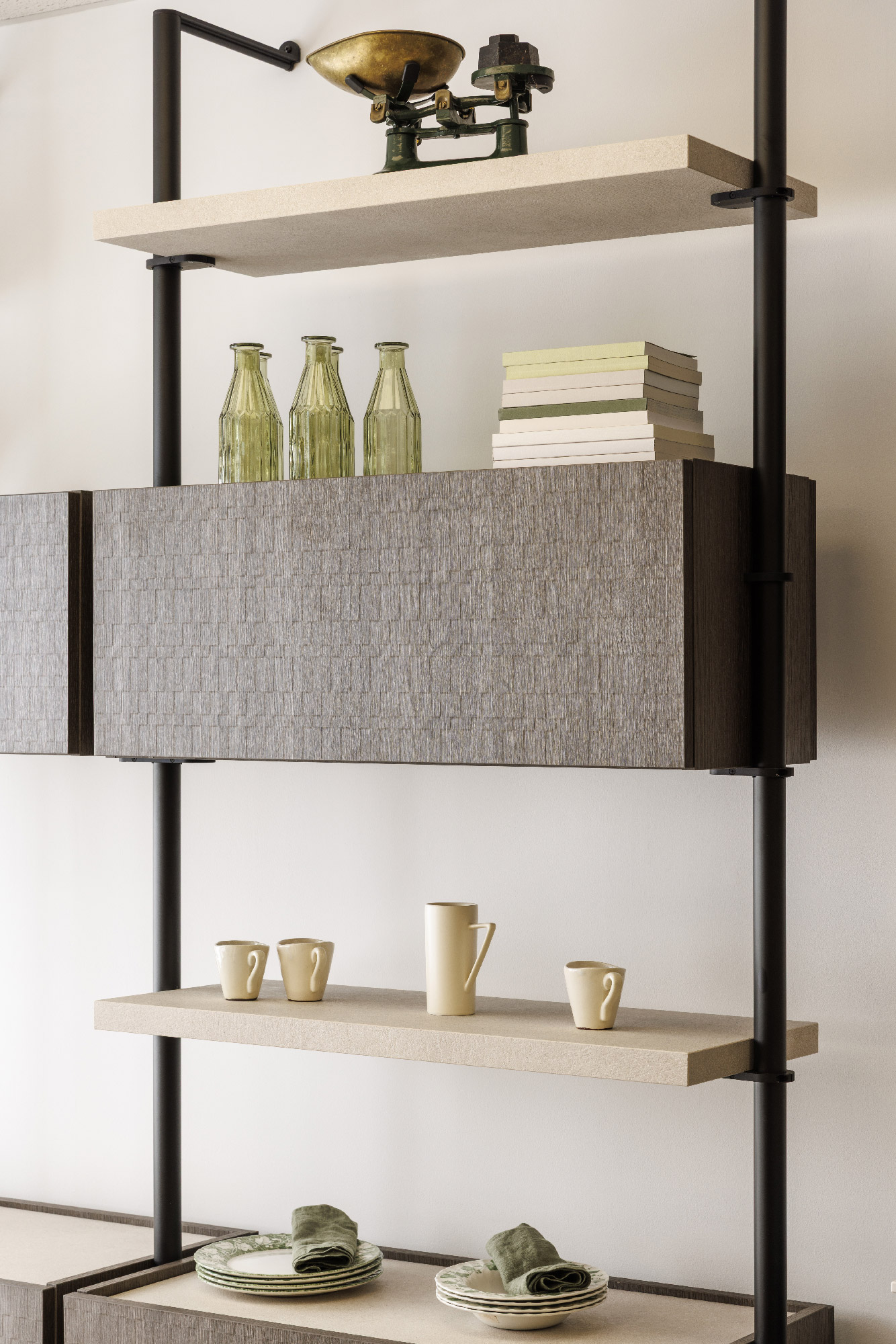 Mensole cucina a giorno con struttura nera e ripiani chiari, bottiglie in vetro verde, bilancia vintage e stoviglie beige su sfondo neutro — arredo moderno showroom Zecchinon Londra