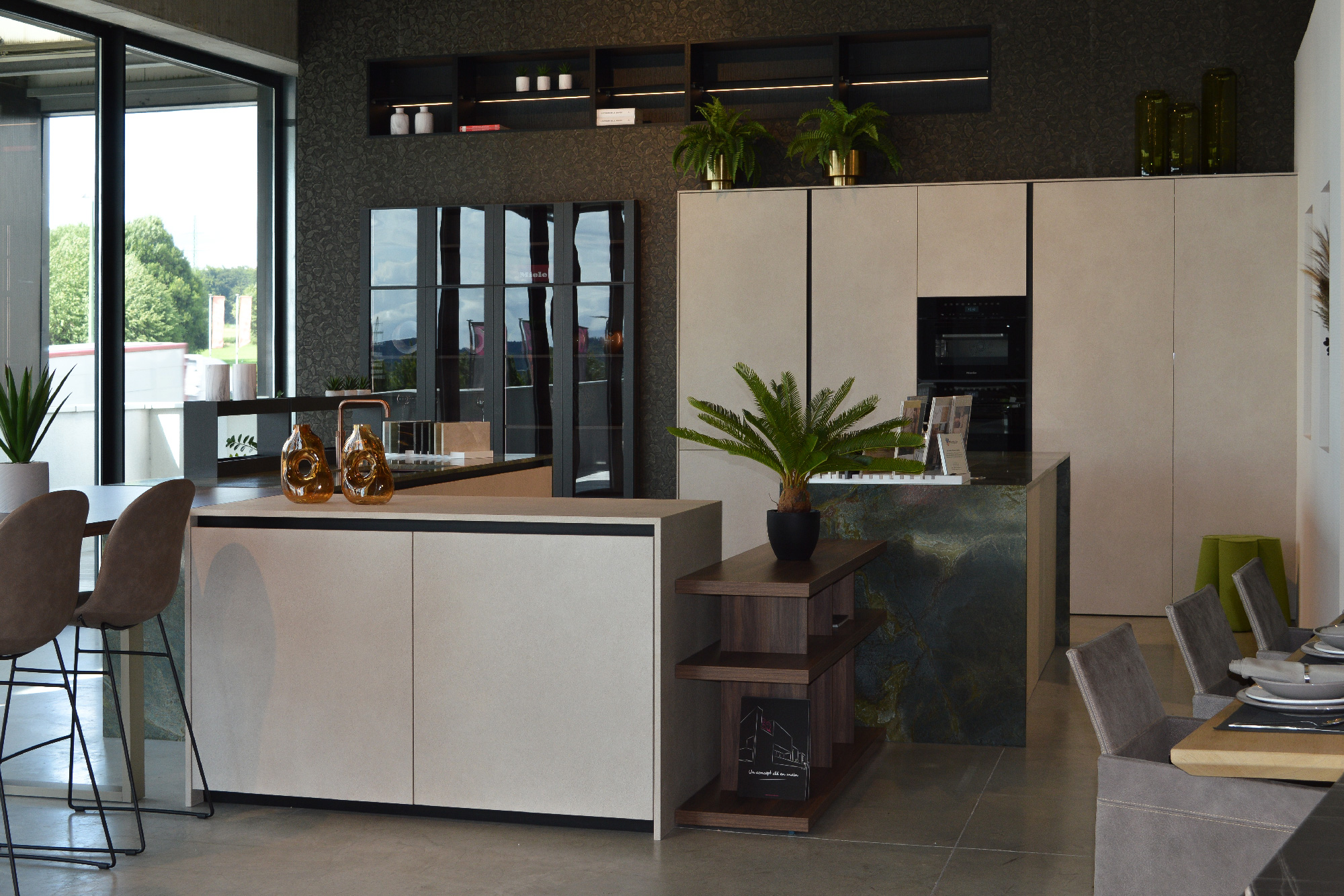 Cucina contemporanea Zecchinon da B&B Concept con isola effetto pietra naturale, ante beige opaco, vetrine nere lucide e arredi con piante e accessori moderni.