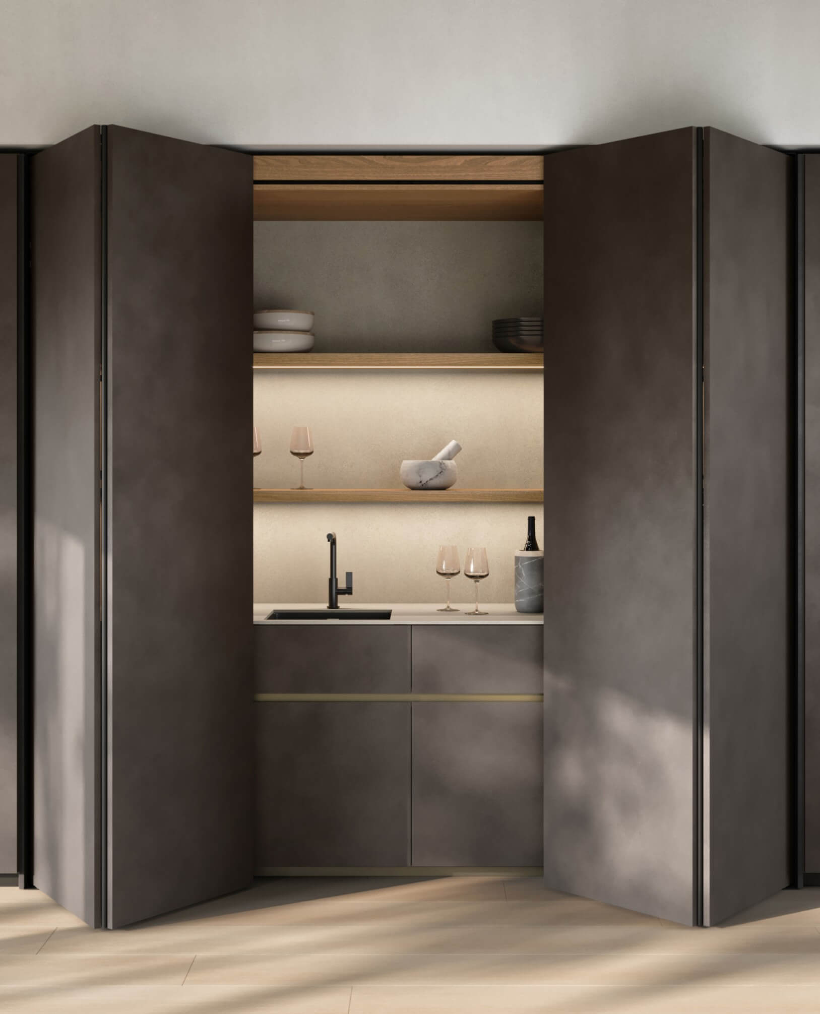 Cucina moderna con sistema Revego: le ante rientranti si aprono mostrando lavello, mensole in legno e ripiani illuminati.