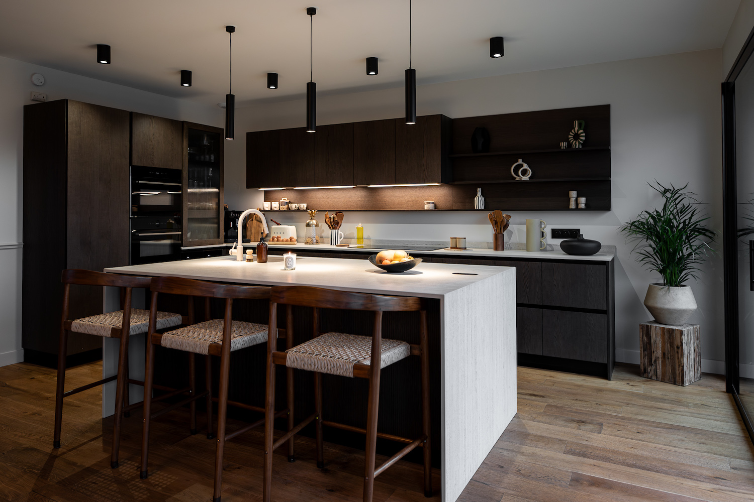 Cucina Zecchinon con isola centrale in legno scuro e piani chiari e luminosi.