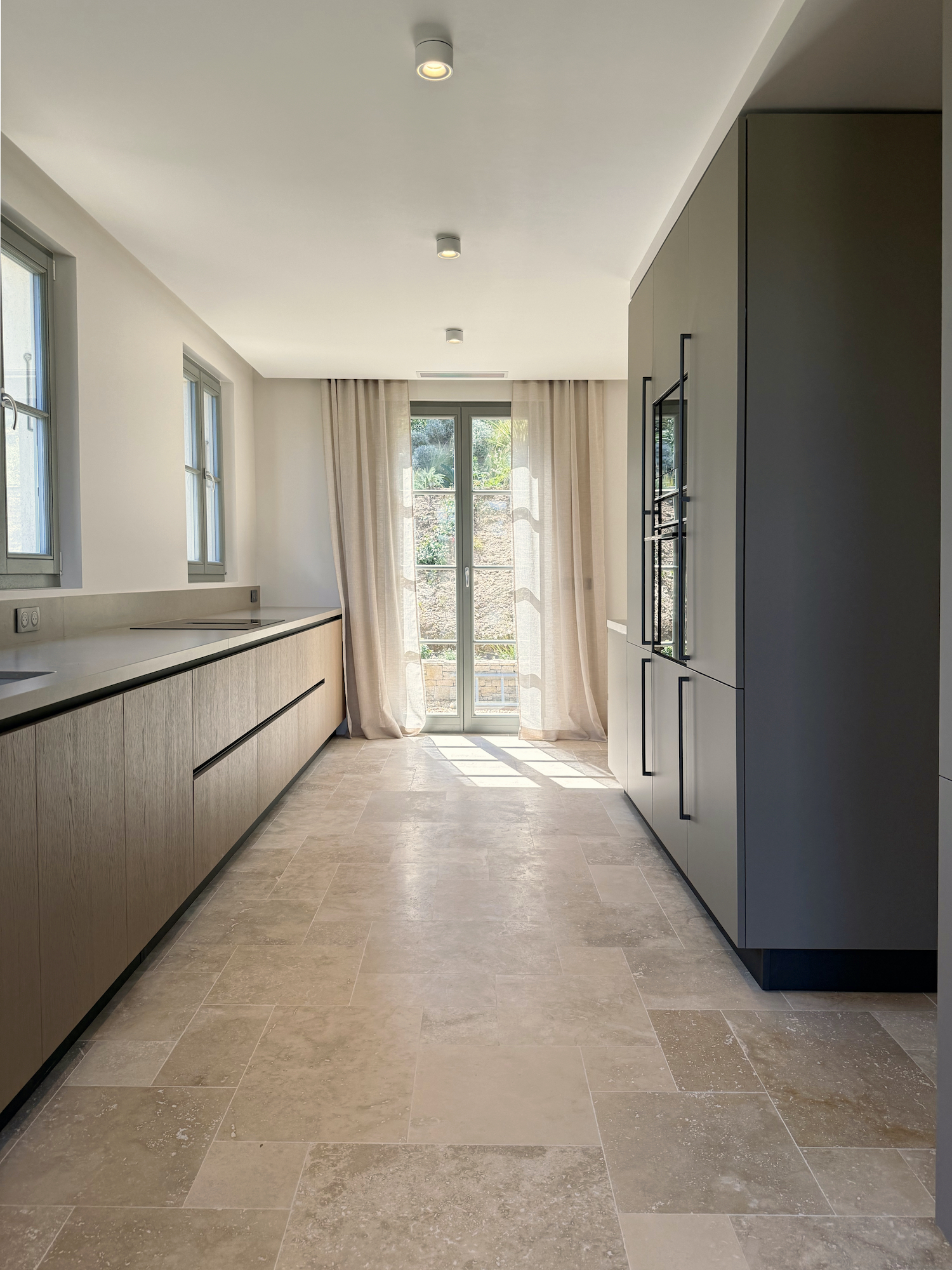 Cucina Zecchinon vista lateralmente con luce che entra dalla porta in vetro. Ante in Fenix NTM opaco. Progetto Zecchinon e Villa 19.6 a Saint-Tropez.