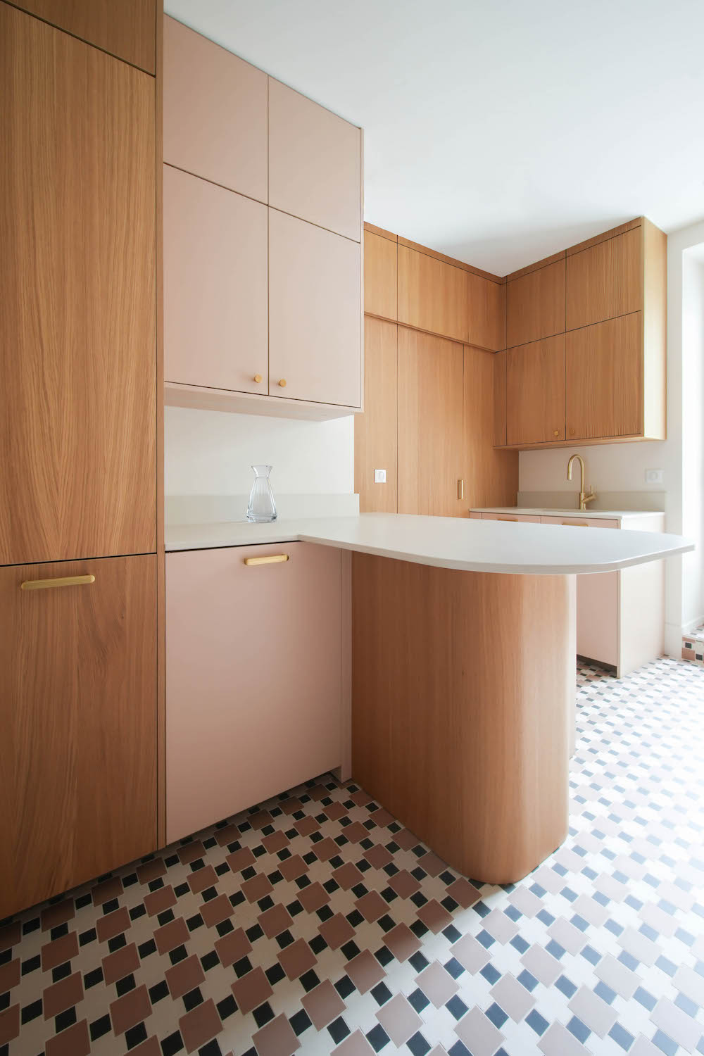 Cucina Zecchinon rosa cipria con porta in legno rovere che da al retrocucina, piccola penisola con piano da lavoro