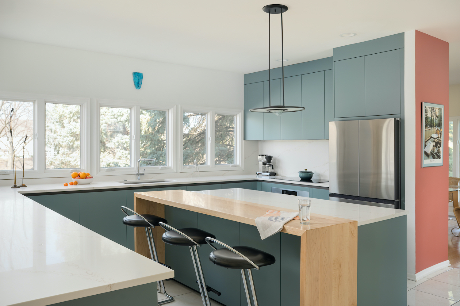 Zecchinon kitchen in a matt lacquer finish, featuring a central island with a marble worktop and a wooden insert. Three stools with black leather seats and steel frames, complemented by modern pendant lighting.