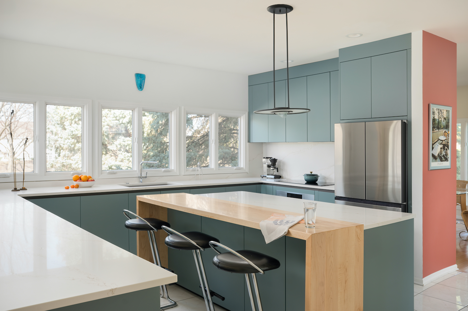 Cuisine Zecchinon en laqué mat avec îlot central doté d'un plan de travail en marbre et d'un insert en bois. Trois tabourets avec assise en cuir noir et structure en acier, suspension lumineuse moderne.