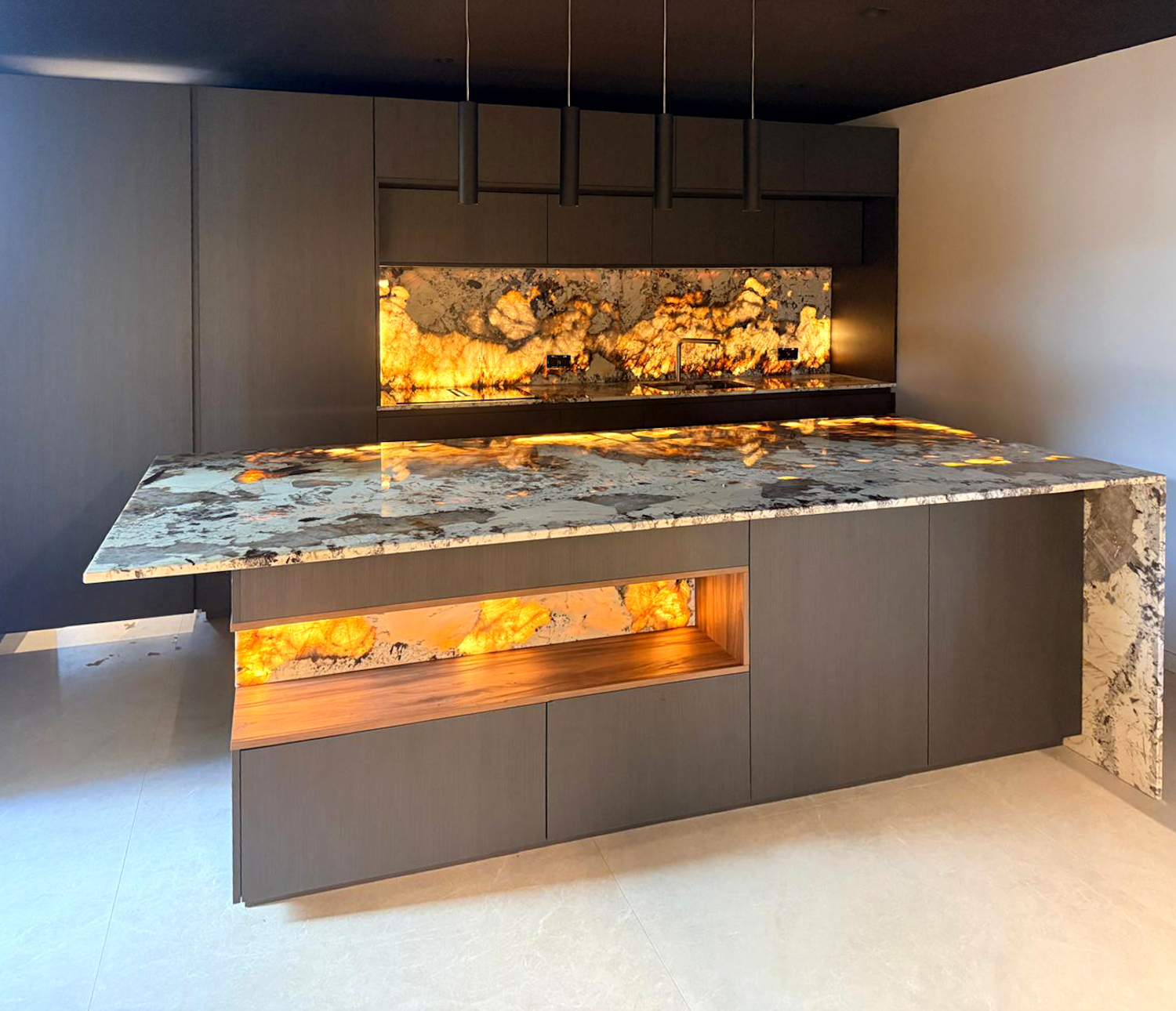 Cucina Zecchinon in materiale tecnico scuro con isola centrale e pietra retroilluminata