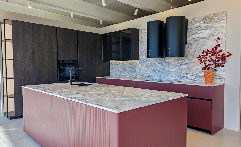 Cucina Zecchinon con isola centrale in materiale tecnico rosso mattone e piano di lavoro in marmo